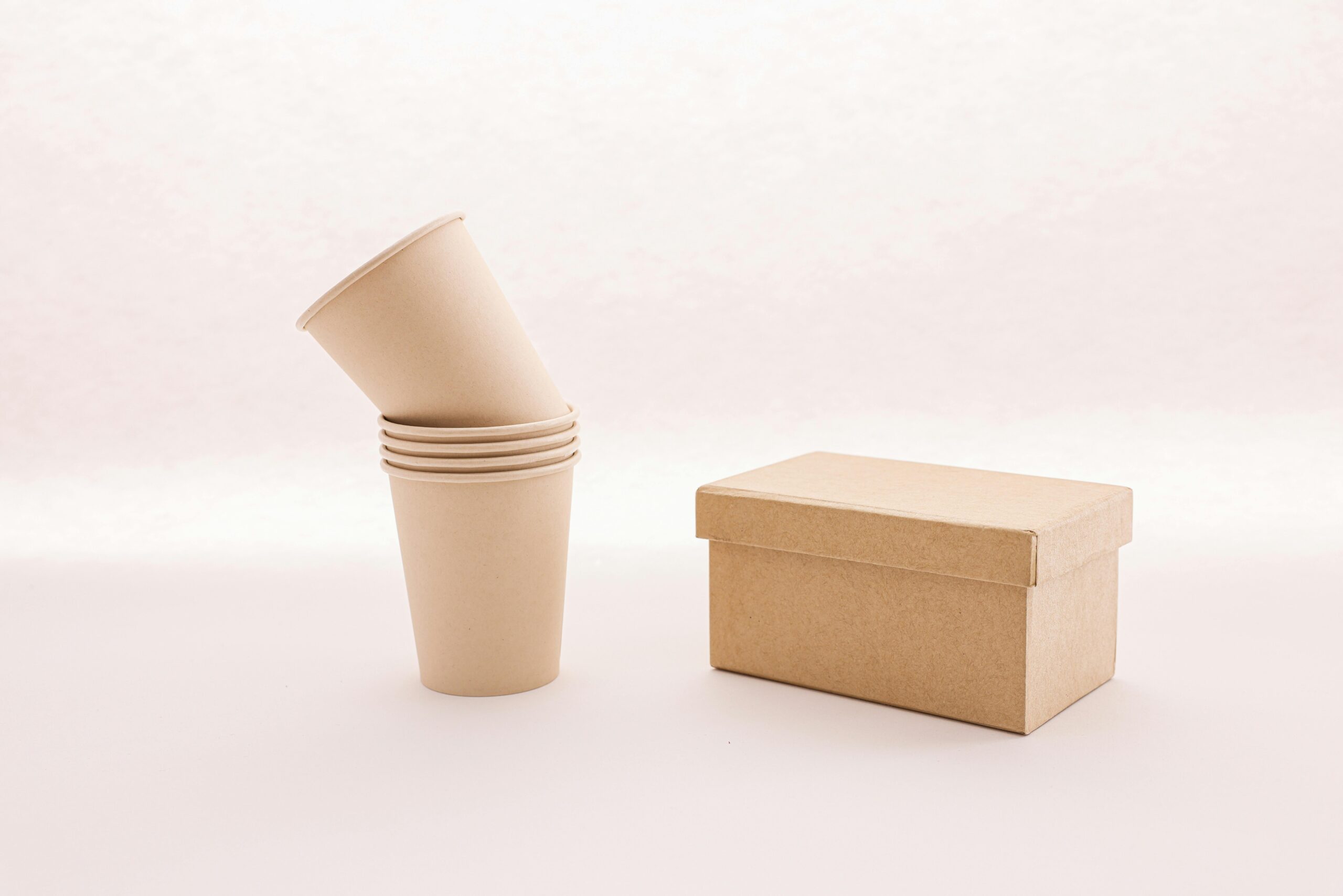 pexels-photo-8015709-8015709 A stack of eco-friendly cardboard cups next to a closed box on a white background.